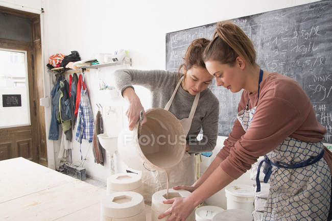 Dois artistas de cerâmica estão escorregando cerâmica em uma oficina de cerâmica . — Fotografia de Stock
