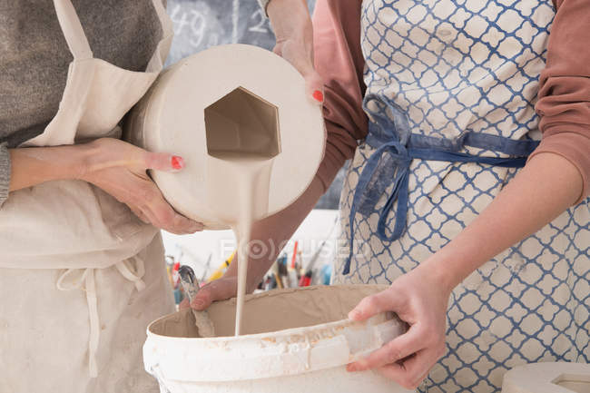 Два керамика художники скольжения керамики в керамической мастерской . — стоковое фото