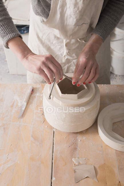 Ein Keramiker ist dabei, in einer Töpferei Keramik zu schleifen. — Stockfoto