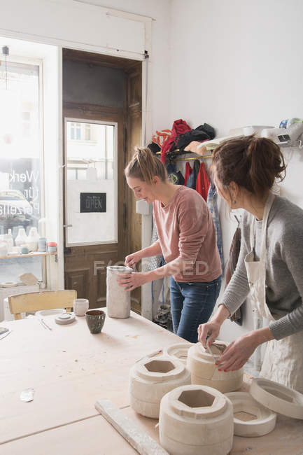 Dos artistas cerámicos están trabajando en su cerámica en un taller de cerámica . - foto de stock