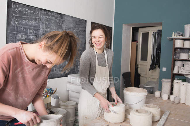 Dois artistas de cerâmica estão trabalhando em sua cerâmica em uma oficina de cerâmica . — Fotografia de Stock