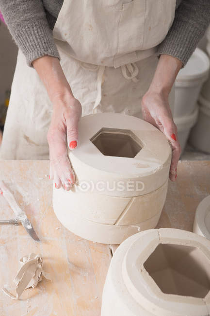 Ein Keramiker ist dabei, in einer Töpferei Keramik zu schleifen. — Stockfoto