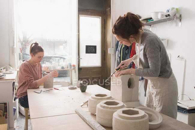 Due artisti della ceramica stanno lavorando alla loro ceramica in un laboratorio di ceramica
. — Foto stock