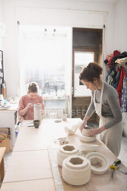 Deux céramistes travaillent sur leurs céramiques dans un atelier de poterie . — Photo de stock