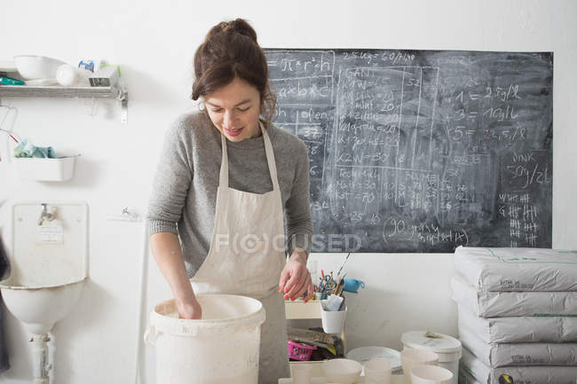 Un artista cerámico está acristalando la cerámica en un taller de cerámica . - foto de stock