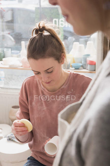 Un artista della ceramica sta mettendo i tocchi finali ad un pezzo di ceramica in un laboratorio di ceramica . — Foto stock