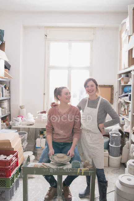 Dos artistas de cerámica sonrientes retratados en su taller de cerámica . - foto de stock