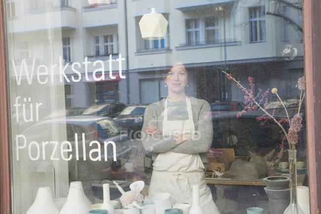 Eine Keramikerin durch das Fenster ihrer Töpferei gesehen. — Stockfoto