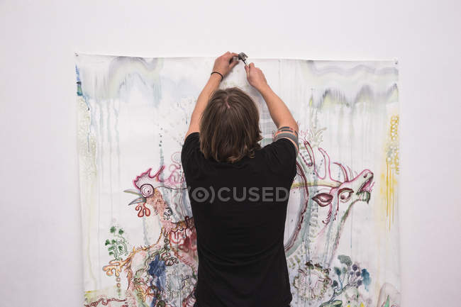 Artiste masculin créatif travaillant dans son atelier, vue arrière — Photo de stock
