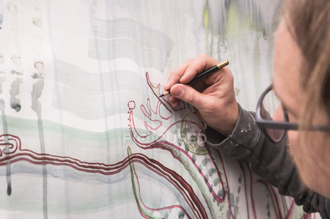 Обрезанный образ творческого мужчины-художника, работающего в своей мастерской . — стоковое фото