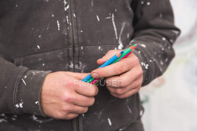 Midsection of Creative male artist holding pencils — Stock Photo