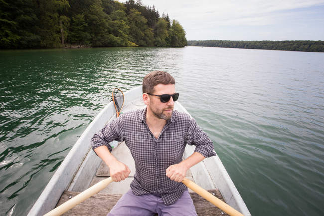 Mann rudert mit Ruderboot auf einem See. — Stockfoto