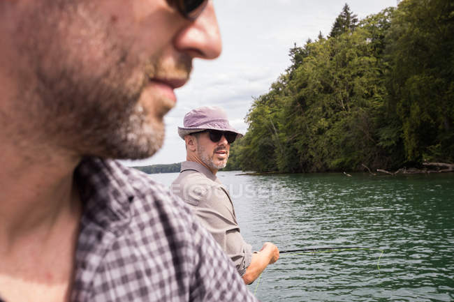 Homens caucasianos são pesca com mosca em barco no lago . — Fotografia de Stock