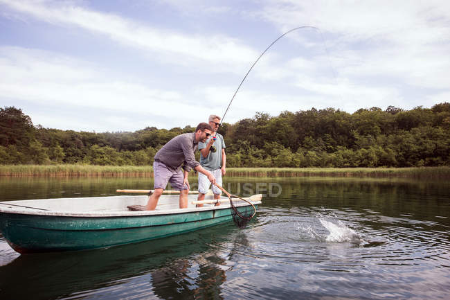 Два рыбака-мухи поймали щуку с лодки на озере . — стоковое фото