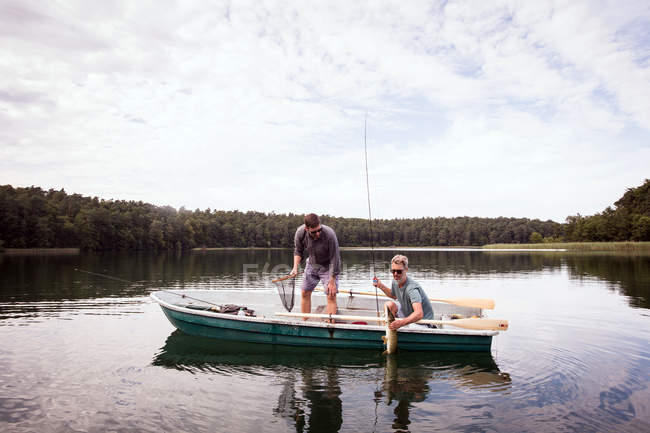 Due pescatori della mosca hanno interferito un luccio da una barca su un lago . — Foto stock