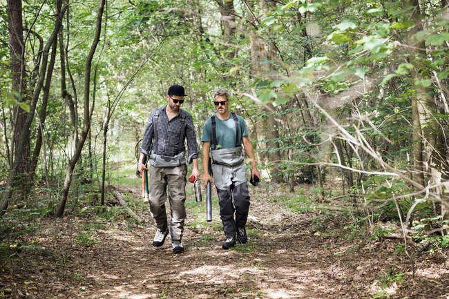 Two men with fly fishing equipment in forest area. — Stock Photo