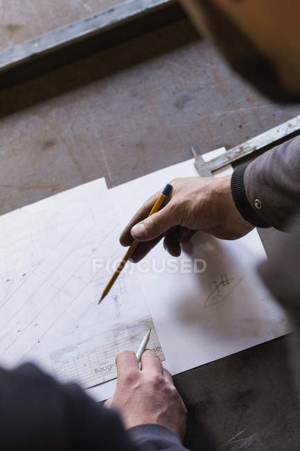 Deux forgerons prennent des mesures, font des calculs et programment une journée de travail dans un atelier de forgeron.
. — Photo de stock