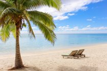 Kochinseln, Aitutaki, malerischer Blick auf den leeren Strand mit zwei Liegestühlen auf Sand — Stockfoto