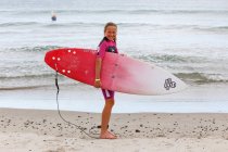 Menina de pé na praia com prancha de surf, Northland, Nova Zelândia — Fotografia de Stock