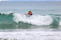 Woman surfing in ocean, New Zealand, Waipu — Stock Photo