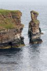 Reino Unido, Escocia, Highland, Wick, Duncansby Head con sus formaciones rocosas dentadas y agujas de roca, Duncansby Stacks junto al mar - foto de stock