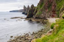 Regno Unito, Scozia, Highland, Wick, Spiaggia di pietra a Duncansby Head con formazioni rocciose e picchi rocciosi — Foto stock