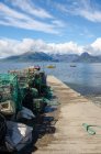 United Kingdom, Scotland, Highland, Isle of Skye, fishing net on pier and boats in Port of Elgol — Stock Photo