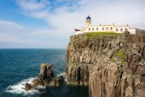Reino Unido, Escócia, Highlands, Ilha de Skye, Glendale, Vista do farol, Neist Point na costa rochosa pelo mar — Fotografia de Stock