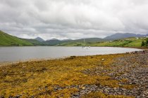 Reino Unido, Escócia, Highland, Ilha de Skye, Carbost, Em Movimento em Highland, Talisker Distillery, paisagem montanhosa cênica por lago — Fotografia de Stock