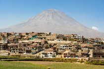 Perú, Arequipa, Vulcano Misti y la pequeña ciudad cercana a la luz del sol - foto de stock