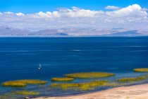 Pérou, Puno, excursion en bateau à Uros, vue aérienne panoramique avec voilier au lac avec des montagnes en arrière-plan — Photo de stock