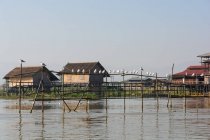 Myanmar (Birmania), Shan, Taunggyi, casas junto al lago Inle, bandada de gaviotas en la construcción de agua de madera - foto de stock