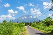 Indonesien, bali, karangasem, grüne Landschaft mit Roller auf dem Weg zum Vulkan agung — Stockfoto