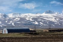 Arménie, province d'Aragatsotn, Aparan, Cabanes au bord des montagnes enneigées — Photo de stock