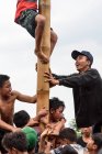 KABUL BULELENG, BALI, INDONESIA - 17 AGOSTO 2015: Teenager del villaggio che scalano il palo di legno unto — Foto stock