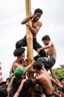 KABUL BULELENG, BALI, INDONESIA - 17 DE AGOSTO DE 2015: Adolescentes del pueblo trepan sobre un poste de madera engrasado - foto de stock