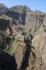 Cabo Verde, Santo Antao, Caibros de Ribeira de Jorge, paisaje pintoresco de montañas verdes con pequeño pueblo sobre roca - foto de stock