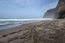 Kap Verde, Santo Fantao, schwarzer Sandstrand an der felsigen Küste, Rückansicht des Wanderers — Stockfoto