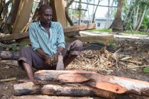 Mann holzbearbeitung mit axt, dhau-bau, nungwi, zanzibar, tansania — Stockfoto