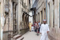 Tanzania, Zanzíbar Stone Town, gente caminando por el callejón - foto de stock