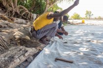 Tanzania, Zanzibar, Zanzibar City, Due uomini che cuciono vela, produzione di vele all'aperto — Foto stock