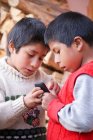 Мальчики, играющие с мобильным телефоном в деревне Мунайчай, Урубамба, Перу — стоковое фото