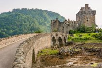 United Kingdom, Scotland, Highland, Dornie, Loch Duich, Eilean Donan Castle with bridge in green landscape — Stock Photo