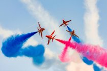 United Kingdom, Scotland, East Lothian, North Berwick, Red Arrows at the annual Scotlands National Airshow in East Fortune, performing aircrafts in sky leaving colorful contrails, bottom view — Stock Photo