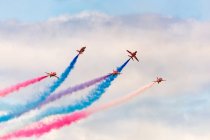United Kingdom, Scotland, East Lothian, North Berwick, Red Arrows at the annual Scotlands National Airshow in East Fortune, performing aircrafts in sky leaving colorful contrails, bottom view — Stock Photo