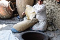 Armênia, Província de Kotayk, Garni, mulher que cozinha lavash — Fotografia de Stock