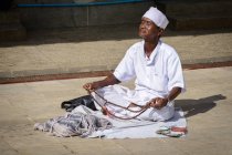 Homme en vêtements blancs priant assis par terre à la pagode Botataung, Yangon, région de Yangon, Myanmar — Photo de stock