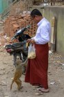 Buddhistischer Mönch füttert Affen mit Bananen, Myingyan, Mandalay Region, Myanmar — Stockfoto