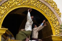 Myanmar, región de Mandalay, hombres pintando el arco de la pagoda Mahamuni - foto de stock