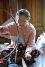 Donna matura lavora sul telaio di filatura, tessitura di seta Lotus, Taunggyi, Shan, Myanmar — Foto stock